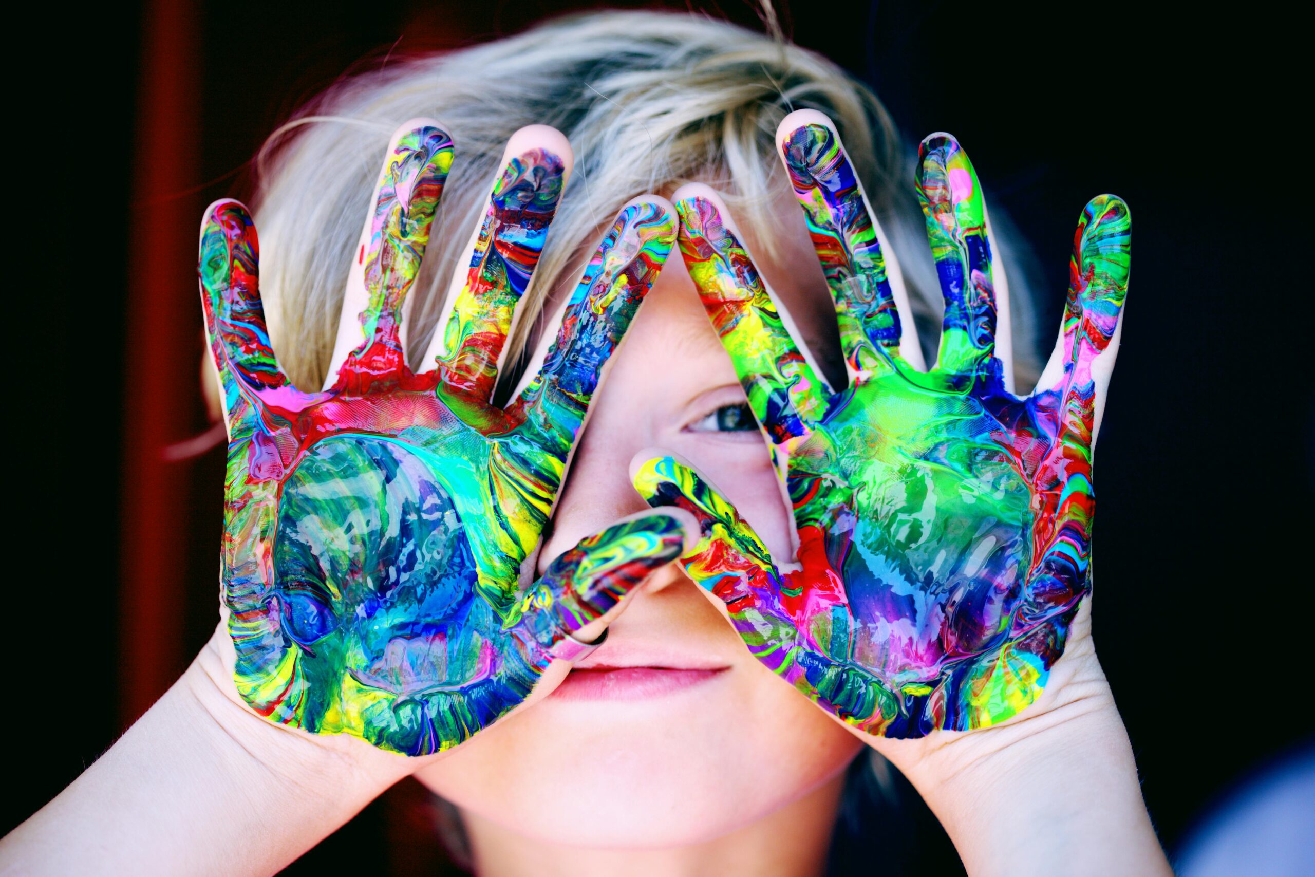 pexels-photo-1148998-1148998 Vibrant close-up of a child's hands covered in colorful paint, expressing creativity and fun.